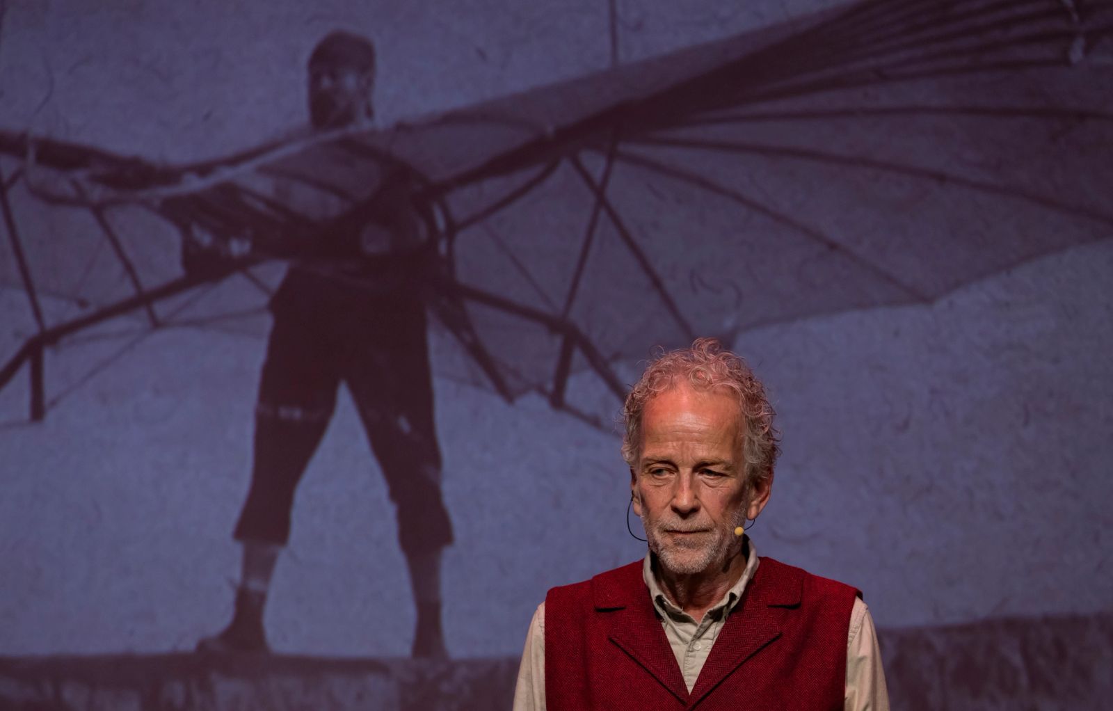 Writer and performer Robert Leddy onstage in his burgundy vest